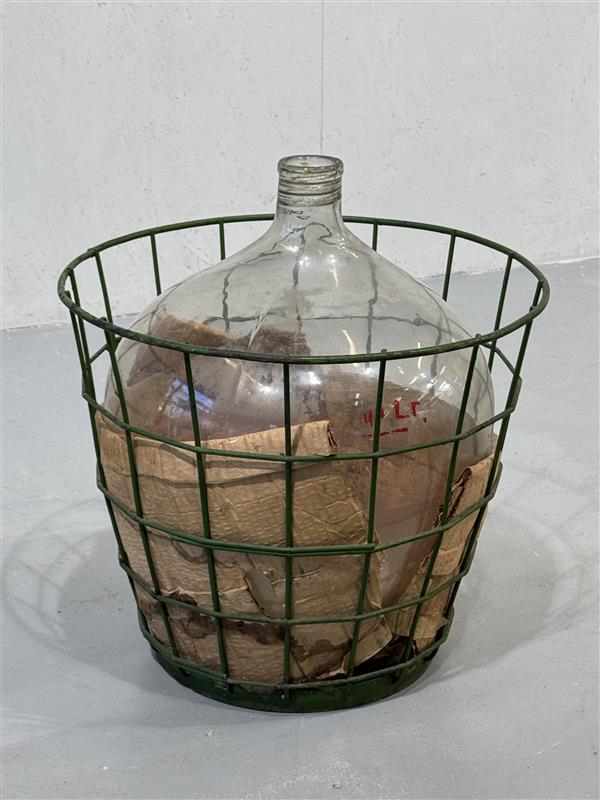 Iso kirkas käymispullo korissa