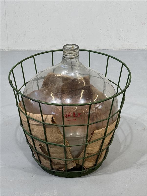 Iso kirkas käymispullo korissa