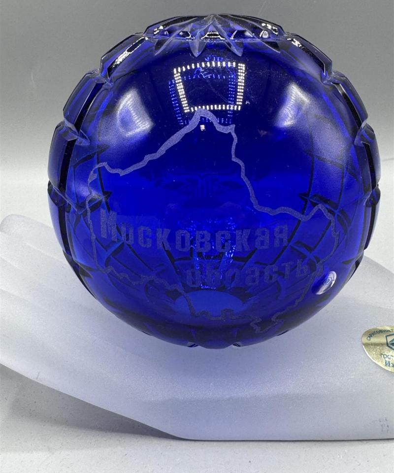 Kristallilasinen koristepallo kädellä 