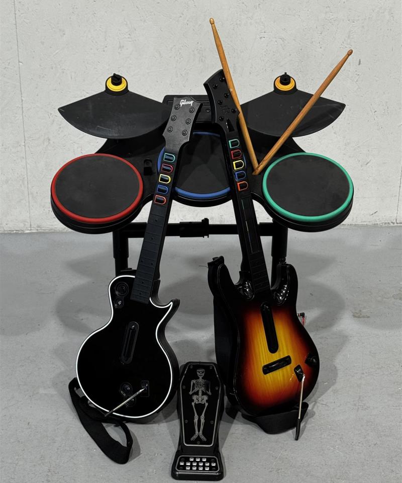 Guitar Hero peliohjainsetti kitaroilla ja rumpupadeilla