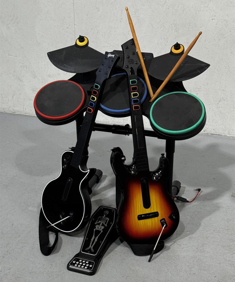Guitar Hero peliohjainsetti kitaroilla ja rumpupadeilla